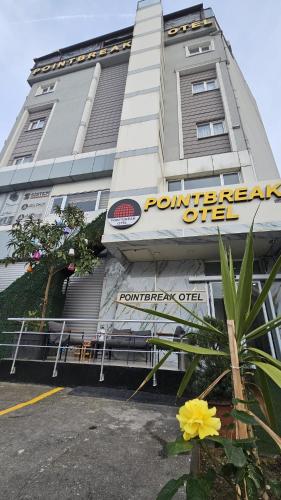 a building with a sign on the side of it at POINTBREAK OTEL in Degirmen