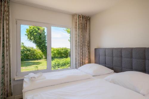 a bedroom with a bed and a large window at Boddenweite 1 in Born