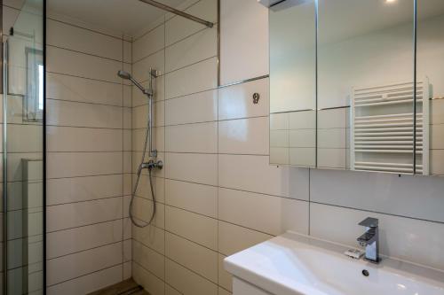 a bathroom with a shower and a sink and a mirror at Boddenweite 1 in Born