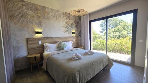 a bedroom with a bed with towels on it at Domaine Lantana in Porto-Vecchio