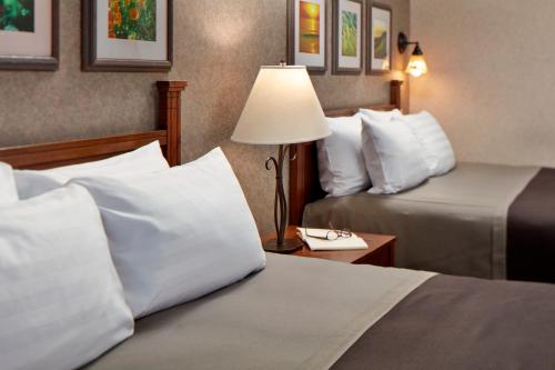 a hotel room with two beds and a lamp at Cavalier Oceanfront Resort in San Simeon