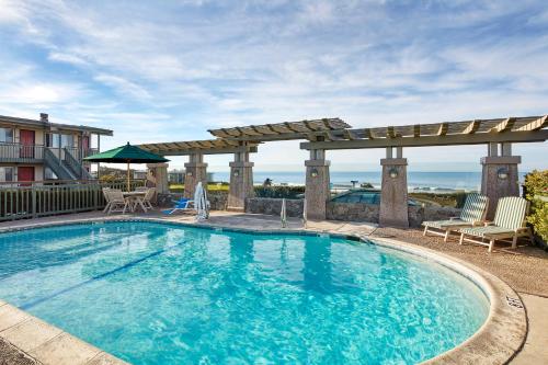 einen großen Pool mit einer Pergola und einer Terrasse in der Unterkunft Cavalier Oceanfront Resort in San Simeon