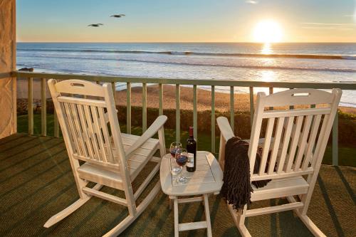 two chairs and a table on a balcony with the beach at Cavalier Oceanfront Resort in San Simeon