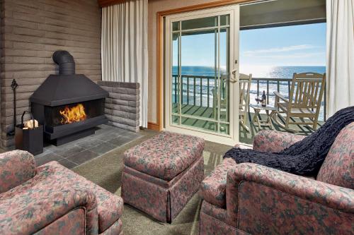 a living room with two chairs and a fireplace at Cavalier Oceanfront Resort in San Simeon