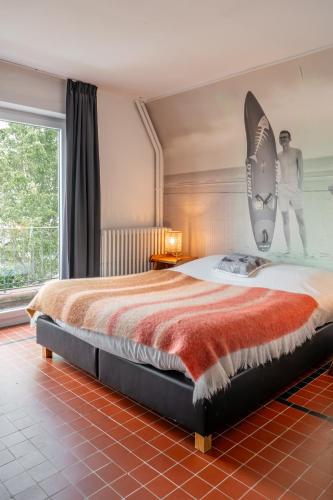 a bedroom with a bed with a surfboard on the wall at Bonnie's Beachhouse - villa aan zee in De Panne