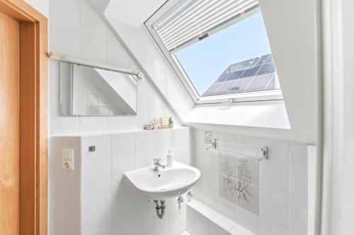 a bathroom with a sink and a skylight at Gasthaus Hirschkeller in Göppingen