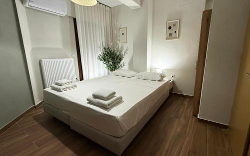 a bedroom with a white bed with towels on it at Athos Villas in Ouranoupoli