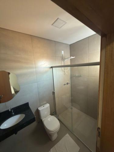 a bathroom with a shower and a toilet and a sink at Hotel Tropical in Aquidauana