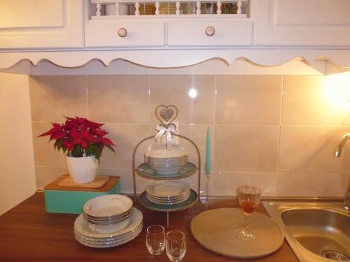 um balcão de cozinha com pratos e copos e um lavatório em Apartment Sime em Zadar