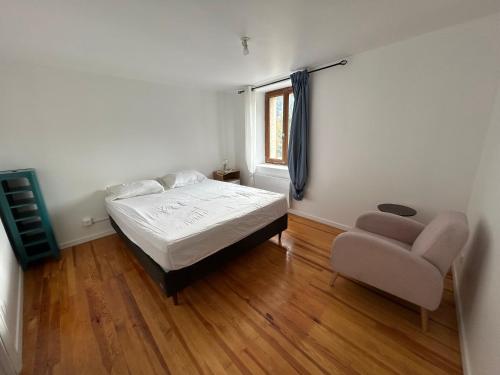a bedroom with a bed and a chair and a window at Appartement Villars Colmars in Villars-Colmars