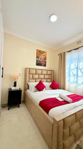 a bedroom with a large bed with red pillows at Serenity Elgon Stay in Eldoret