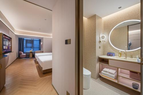 a bathroom with a bed a sink and a mirror at Manxin Hotel Xian Bell Tower in Xi'an