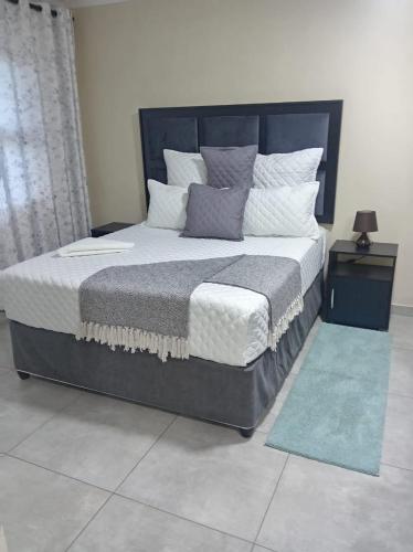 a bedroom with a large bed with pillows at Sydney's Guest House in Johannesburg
