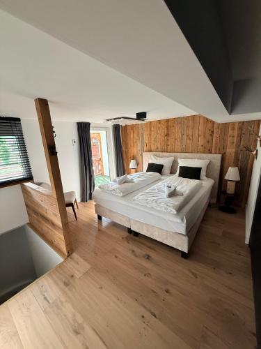 a large bedroom with a large bed and wooden floors at Alpin Haus Berwang in Berwang