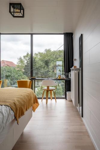 a bedroom with a bed and a large window at B&B Armalot by Julia in De Panne