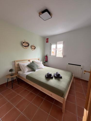 a bedroom with a bed with two hats on it at La Casita de Sara in Cercedilla