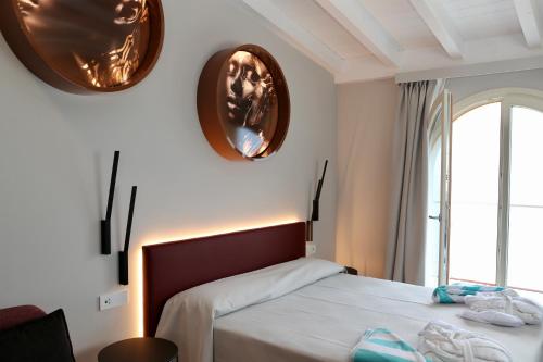 a bedroom with a bed and two mirrors on the wall at Villa Helena in Limone sul Garda