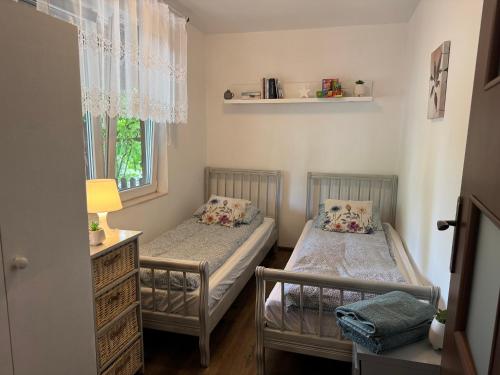 two twin beds in a small room with a window at Bokaczówka in Ustka