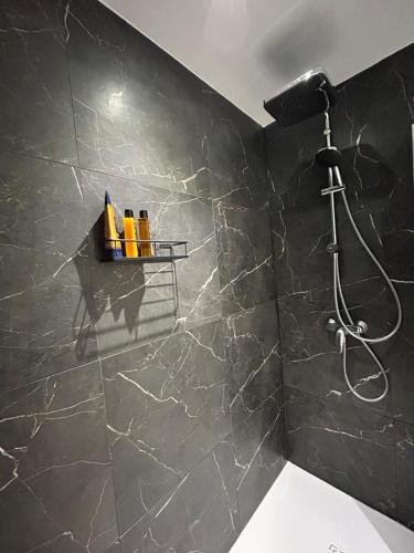 ein Badezimmer mit Dusche und schwarzer Wand in der Unterkunft Palazzo Modafi in Bagni di Lucca