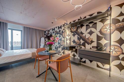 a hotel room with a bed and a table and chairs at Loft 23 Boutique Hotel in St. Julianʼs