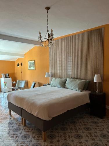 ein Schlafzimmer mit einem großen Bett und einem Kronleuchter in der Unterkunft Palazzo Modafi in Bagni di Lucca