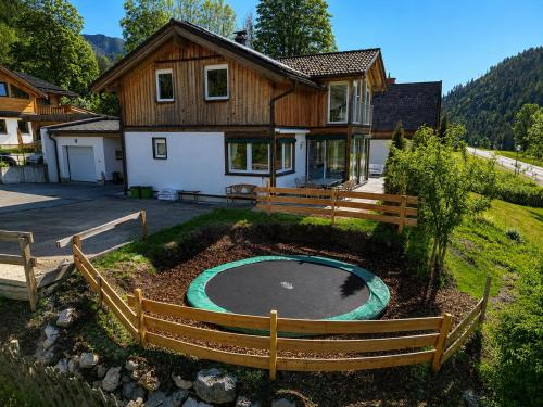 a house with a pool in front of a yard at Gipfelruhe-ganzes Ferienhaus mit Sauna, Garten & Spielzimmer- Ramsau am Dachstein in Ramsau am Dachstein