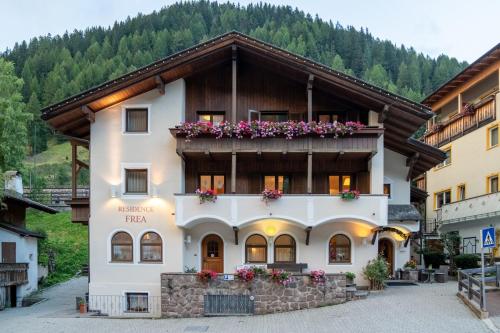 a building in the mountains with flowers on it at Residence Frea in Selva di Val Gardena