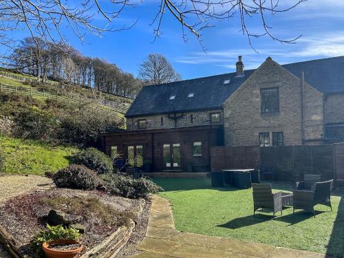 a large brick house with a bench in the yard at Ash Cottage - Ukc9266 in Hope