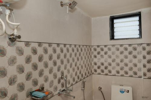 a bathroom with a shower and a toilet and a window at Ananda Villa in Igatpuri