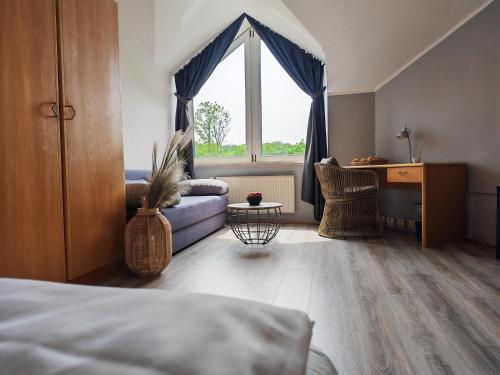 a bedroom with a bed and a couch and a window at Pure Hotel Dänischer Hof in Altenholz