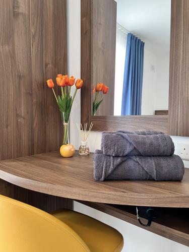 a wooden table with orange flowers in a mirror at Seaview Marsaxlokk Apartment Eye of Osiris in Marsaxlokk