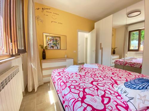 a bedroom with a bed with a pink blanket at La Casina di Perla in Viareggio