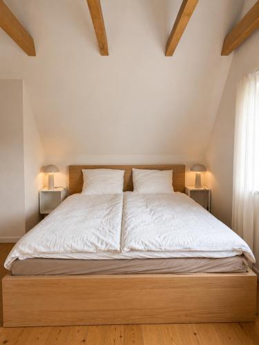 a bedroom with a large bed with white sheets and pillows at Nice Nest Villa Hotels in Odense