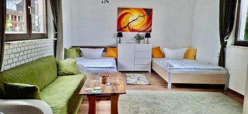 a living room with a green couch and a table at Ferienwohnung Lebensbaum in Trimberg in Elfershausen