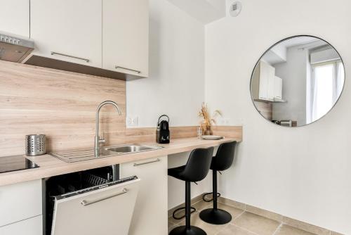 a kitchen with a sink and a mirror at La Petite Maison - Studio in Peyriac-de-Mer