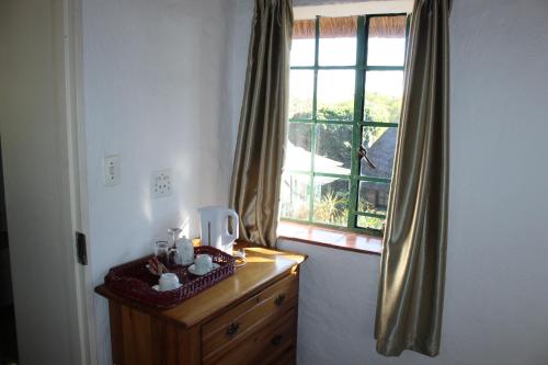 a room with a window and a wooden dresser with a dresserngthngth at Gender Links Cottages in Johannesburg