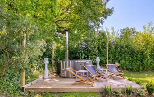 a group of chairs sitting on a wooden deck at Maisons Falourdel in Soulles