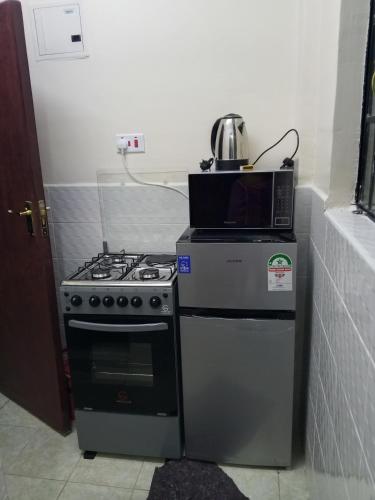 a microwave sitting on top of a stove in a kitchen at Halcon Homes Machakos Boma Yangu in Machakos