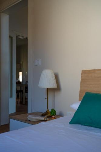 a bedroom with a bed with a lamp on a table at Casa di charme "Al Moro Avola " in Avola