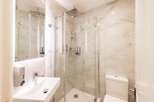a bathroom with a shower and a toilet and a sink at Seven Paddington in London