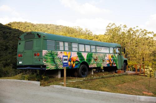 a green bus is parked in the grass at D'Alma Bus com café da manhã in Pomerode