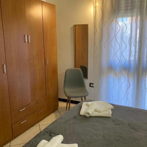 a bedroom with a bed and a chair and a cabinet at Casa Vacanza Margherita in Assemini