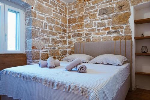 a bed in a room with a brick wall at Nada Apartment near Krka National Park in Skradin