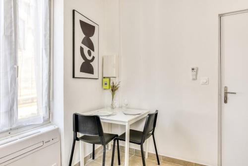 a white table and chairs in a white room at La Petite Maison - T1 Bis in Peyriac-de-Mer