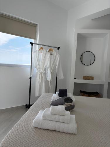 a bedroom with a bed with towels on it at Eolia luxury suites Andros in Batsi