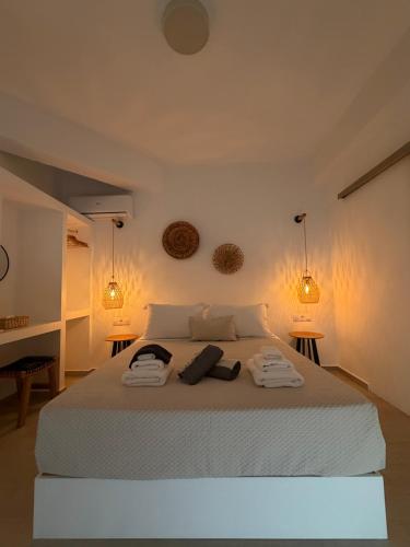 a bedroom with a white bed with two towels on it at Eolia luxury suites Andros in Batsi
