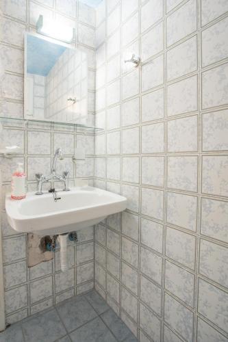 a white bathroom with a sink and a mirror at Blue White House in Kalamitsi