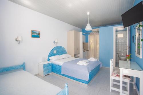 a blue and white bedroom with a bed and a desk at Blue White House in Kalamitsi