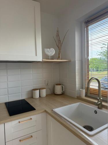 eine weiße Küche mit Spüle und Fenster in der Unterkunft Rewa House in Rewa
