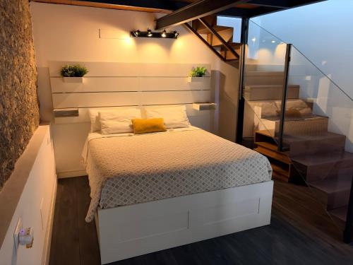 a small bedroom with a bed and some stairs at LOFT La Palma in Almería